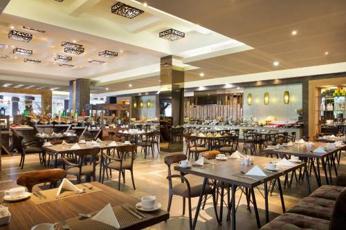 a restaurant with tables and chairs in a room at Holiday Inn Cikarang Jababeka by IHG in Cikarang