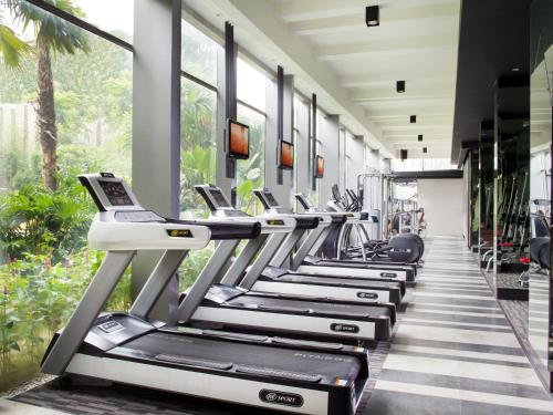 a row of treadmills in a gym with windows at Holiday Inn Cikarang Jababeka by IHG in Cikarang