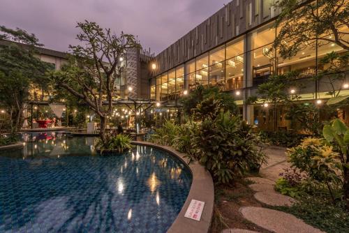 a hotel with a swimming pool in front of a building at Holiday Inn Cikarang Jababeka by IHG in Cikarang