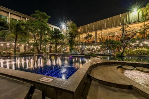 a swimming pool in front of a building at night at Holiday Inn Cikarang Jababeka by IHG in Cikarang