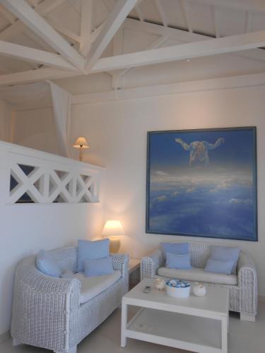 una sala de estar con 2 sofás y una pintura en la pared en HydraVista (Lily) en Hydra
