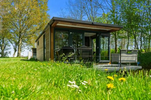 a tiny house in the middle of a field at Houseboats Pean-buiten Weidum in Weidum