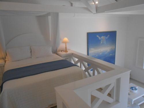 1 dormitorio con 1 cama y una pintura en la pared en HydraVista (Lily) en Hydra