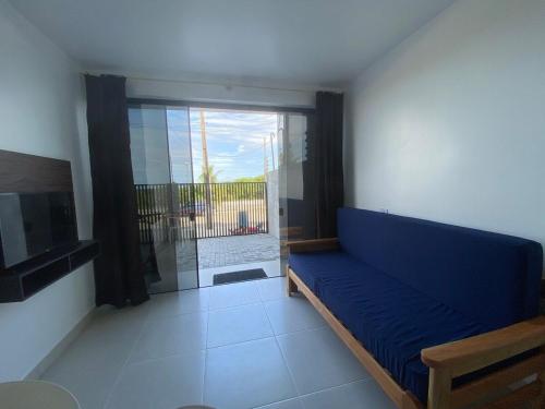 a living room with a blue couch and a large window at Condominio Boa Vista in Pontal do Paraná
