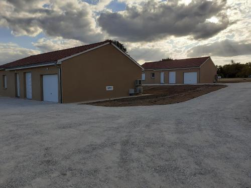 a building with two garage doors on a lot at L'Epicurienne in Simandre