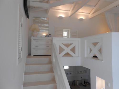 Habitación blanca con escaleras y vestidor en HydraVista (Lily) en Hydra