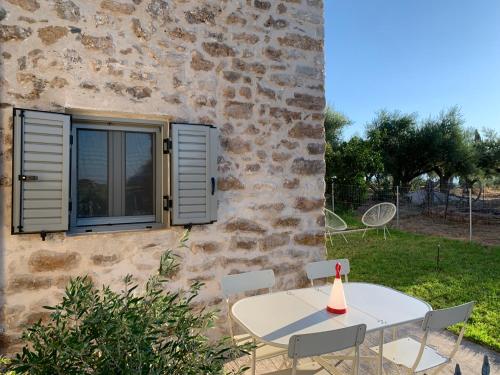 a table and chairs in front of a stone building at Messinian Stone House in Messini