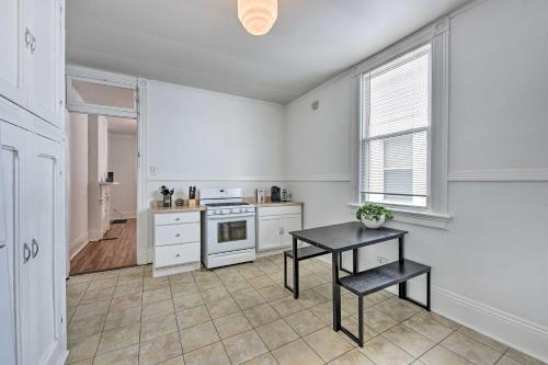 a white kitchen with a table and a stove at Historical NOLA Home about 3 Mi to French Quarter in New Orleans