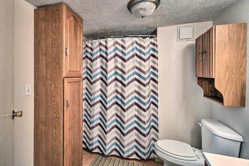 a bathroom with a toilet and a shower curtain at Peaceful Satsuma Escape with Dunns Creek Access in Satsuma