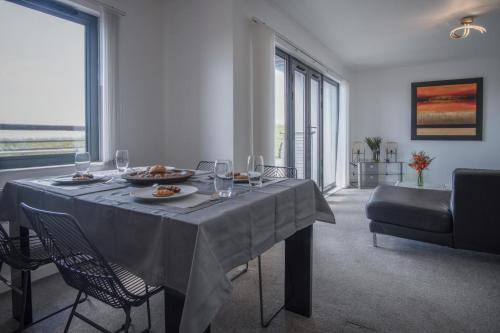 a dining room with a table with food and wine glasses at Maritime Quarter - 2 Bedroom Apartment - SA1 Beach Front Fishermans Way in Swansea