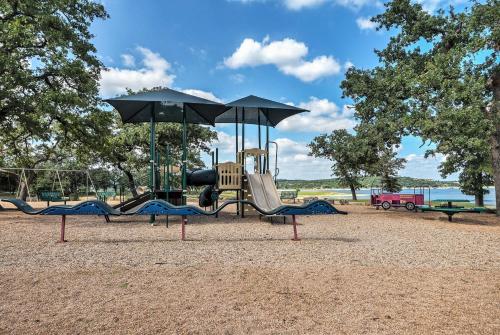 a playground with a slide and an umbrella at Modern Lago Vista Home with Pool and Lake Access! in Lago Vista