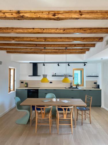Il comprend une cuisine et une salle à manger avec une table et des chaises en bois. dans l'établissement Ancient & Modern, à Šibenik