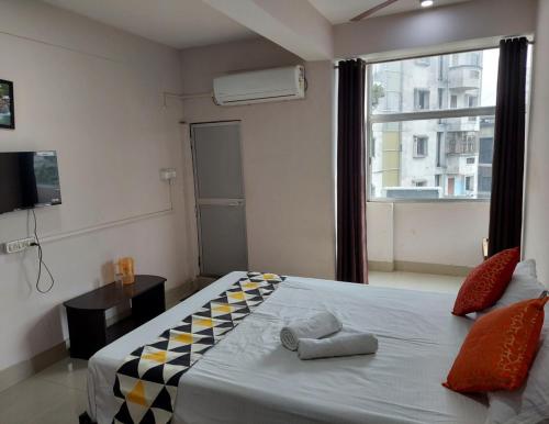 um quarto com uma cama grande e uma janela em Raison Hotel em Jamshedpur