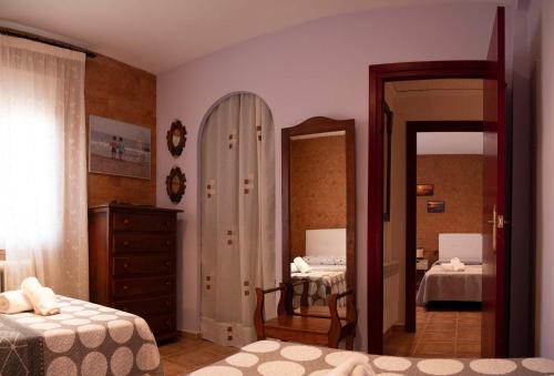 a bedroom with two beds and a mirror at LA CASA DE ROSA in Teruel