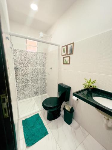 a bathroom with a green toilet and a sink at Pousada Harmonia in Tamandaré