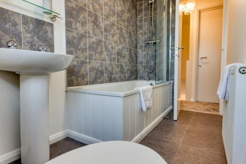 y baño con lavabo y bañera. en Casa Cella - Centrally located 4 bedroom house with private driveway and garden en Kent
