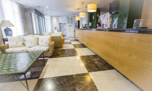 a lobby with a bar with couches and a table at Balneario de Archena - Hotel Levante in Archena
