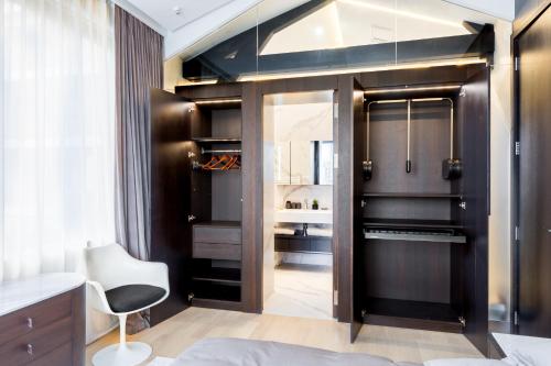 a bedroom with a black closet and a white chair at Ravissant loft avec vue sur Seine in Courbevoie