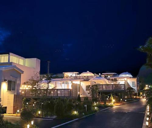 a night view of a large building with lights at Necoana Glamping富士山景BBQトレーラーヴィラ in Fujikawaguchiko
