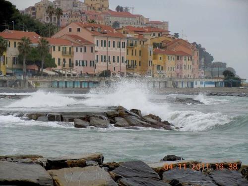 a group of waves in the ocean with buildings at Casa del vecchio artista in Imperia