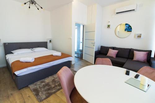 a bedroom with a bed and a couch and a table at Gajeva Rooms SELF CHECK-IN in Virovitica