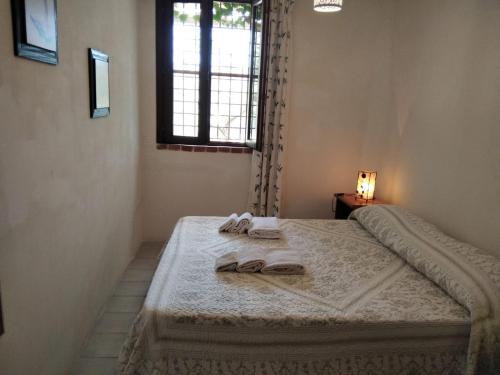 een slaapkamer met een bed met twee slippers erop bij casale guidaloca in Castellammare del Golfo
