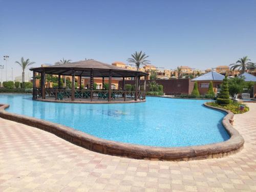 uma grande piscina com um gazebo num resort em Villa Yasmin404 em Marsa Matruh