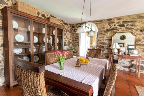 a dining room with a table with flowers on it at Casa das Regueiras in Santiago de Compostela