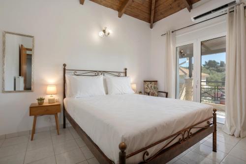 une chambre avec un grand lit et une fenêtre dans l'établissement Casa Callianeira Residence, à Tsilivi