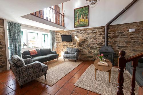 a living room with a couch and a fireplace at Casa das Regueiras in Santiago de Compostela