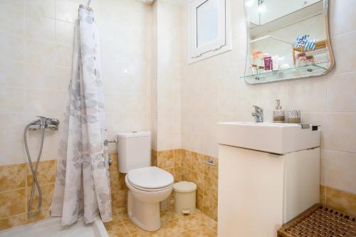 a bathroom with a toilet and a sink and a shower at Casa Callianeira Residence in Tsilivi