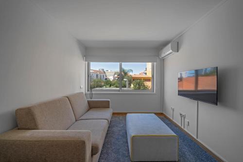 een woonkamer met een bank en een flatscreen-tv bij Oporto Near Poveiros in Porto