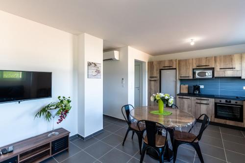 une cuisine et une salle à manger avec une table et des chaises dans l'établissement Les Terres Rouges, à Aléria