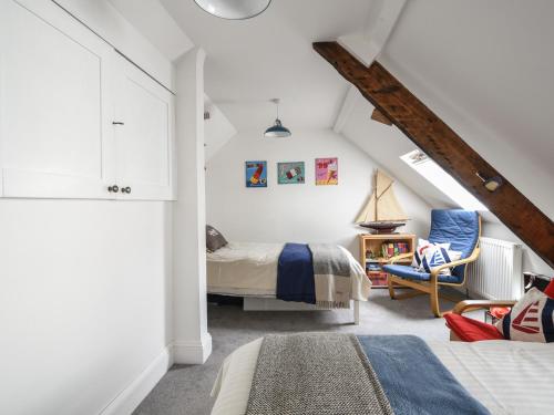 een slaapkamer met een bed en een stoel op zolder bij Rooby's Retreat in Lyme Regis