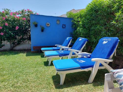 a group of blue chairs sitting in the grass at Beach and Golf House La Cala de Mijas in La Cala de Mijas