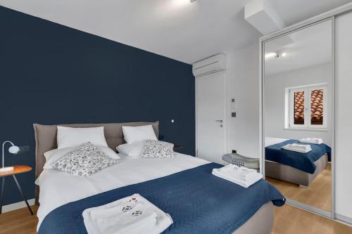 a bedroom with a large bed and a mirror at The Square Makarska, LUX app in the heart of the city in Makarska