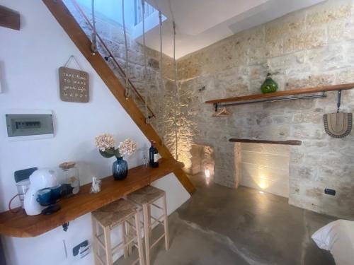 a room with a staircase and a stone wall at Dimora PietrAnima in Bari