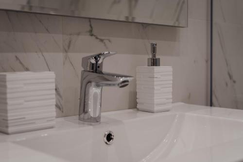 a bathroom sink with a faucet and stacks of paper towels at DOMUS RESIDENCE - CESARE - in Bari