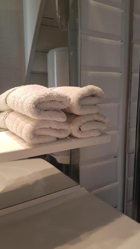 une pile de serviettes assises sur une étagère dans une salle de bains dans l'établissement Maison vue Cité 2, à Carcassonne