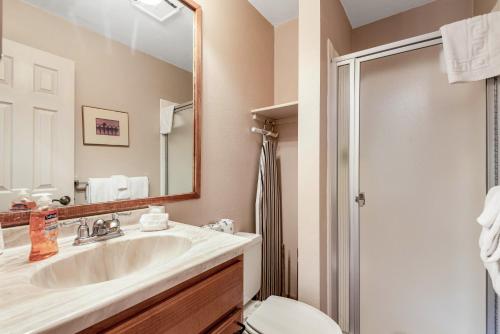 a bathroom with a sink and a toilet and a mirror at Copper Junction 305 in Frisco