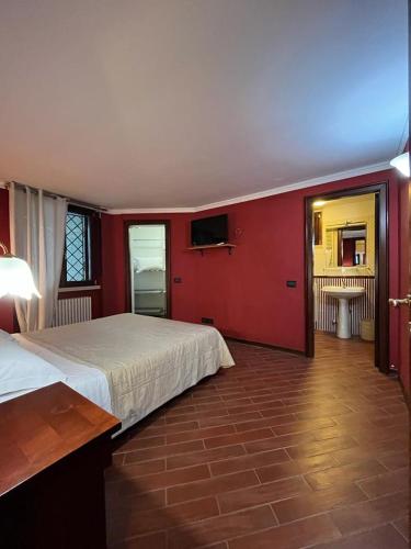 ein Schlafzimmer mit einem Bett und einer roten Wand in der Unterkunft Petite Home in Roccaraso