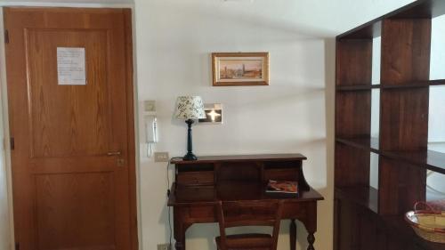 Habitación con puerta y mesa con lámpara en Residence Domus, en Pisa