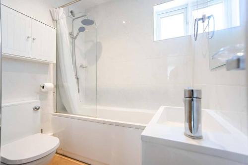 a white bathroom with a toilet and a shower at Beautiful 3 bedroom home, 10 minutes walk to Beach. in Cleethorpes