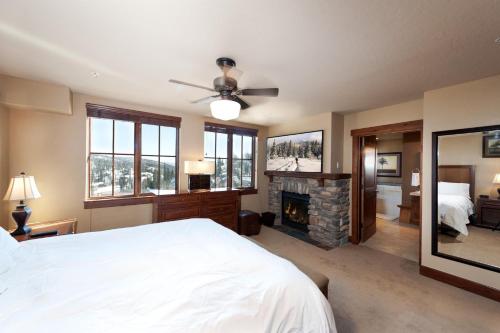 a bedroom with a white bed and a fireplace at Purgatory Lodge Unit 507 in Durango Mountain Resort