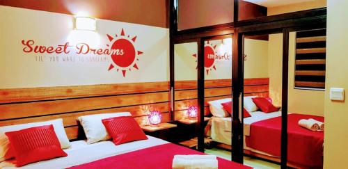 1 dormitorio con 2 camas con sábanas rojas y blancas en Flic en Flac Sea View Luxury 3 bedroom Apartment, en Flic en Flac