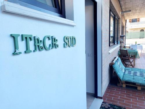 a sign on the side of a building with a bench at Itaca in Lido di Fermo