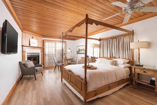 a bedroom with a canopy bed and a desk at Inn On SummerHill in Summerland