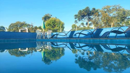 a swimming pool with its reflection in the water at Pousada do Sossego in Extrema