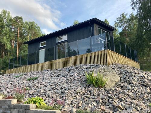 a black house on top of a pile of rocks at Cabin in the woods, close to Lake Mälaren in Eskilstuna