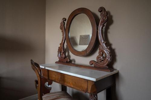 a mirror sitting on top of a wooden table at Casa di Melo - Organic Country Hotel in Cassibile